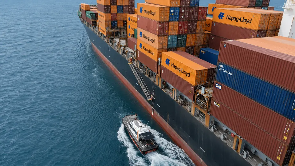 Lancha de prático ao costado de navio porta-contêineres